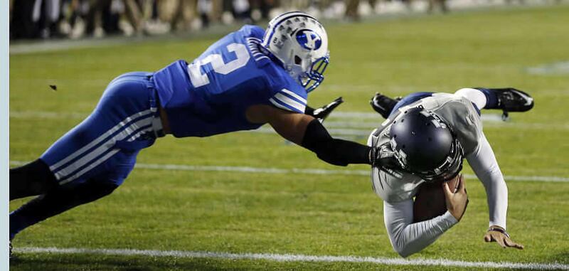 Darell Garretson (10) of the Utah State Aggies dives in for a touchdown while defended by Dallin Leavitt (2) of the Brigham Young University Cougars during NCAA football in Provo, Friday, Oct. 3, 2014.