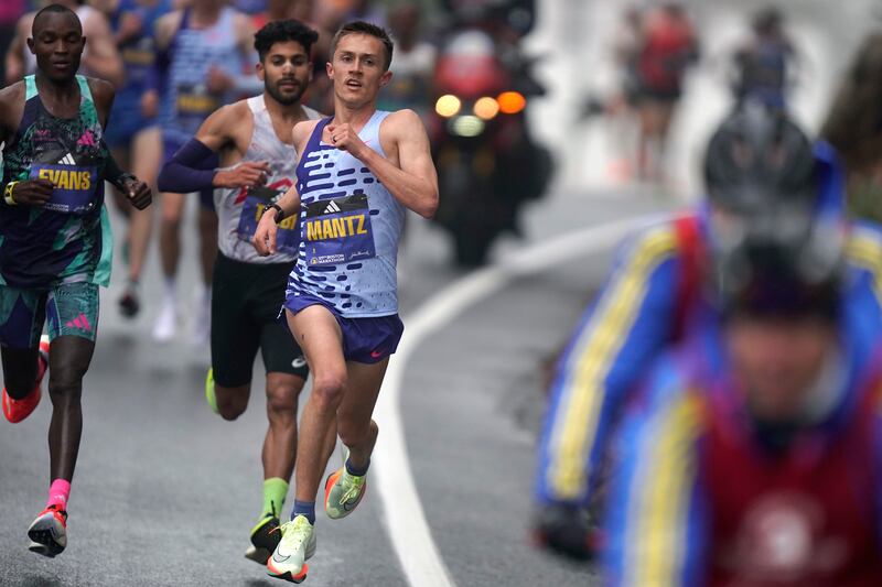 Conner Mantz, of the United States, center, runs near Evans Chebet, of Kenya, left, during the 127th Boston Marathon.