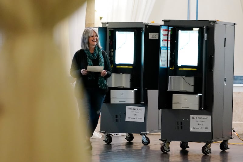 A vote walks away after casting their ballot in Georgia’s Senate runoff election on Tuesday, Jan. 5, 2021, in Atlanta. (AP Photo/Brynn Anderson)