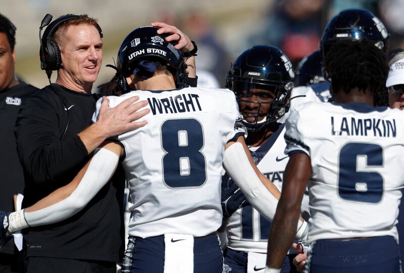 Utah State’s Derek Wright is congratulated by coach Blake Anderson during game vs. New Mexico, Nov. 26, 2021, in Albuquerque