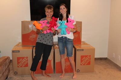 On June 21, 2018, Leann Hansen, left, and Sarah Carmichael Parson, right, stand with 10 boxes of stuffed dolls and bears that were later sent to the children who were separated from their parents at the U.S.-Mexico border. Since its creation in 2015, Doll