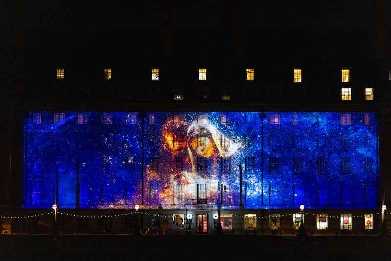 An image of Joseph and Mary looking at the baby Jesus illuminates the side of London County Hall on Nov. 13, 2024.