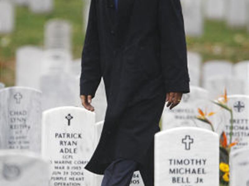 President Barack Obama walks through grave markers in Arlington, Va.