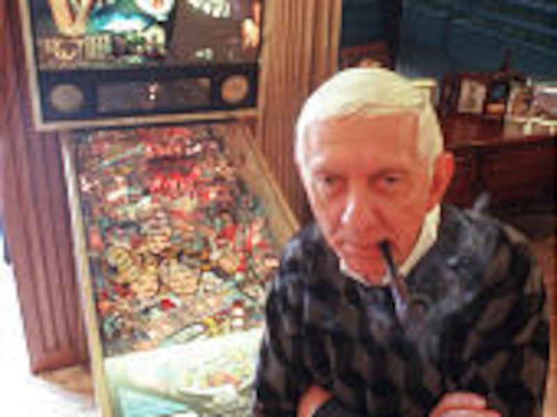 TV producer Aaron Spelling relaxes in his Los Angeles office in February 1996. On the pinball machine behind him are pictures of his family members and characters from his hit television shows.
