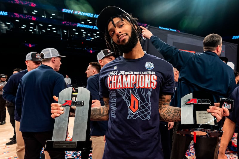 Duquesne 's Dae Dae Grant poses with his trophies for the all-tournament team and most outstanding player after game against Virginia Commonwealth.