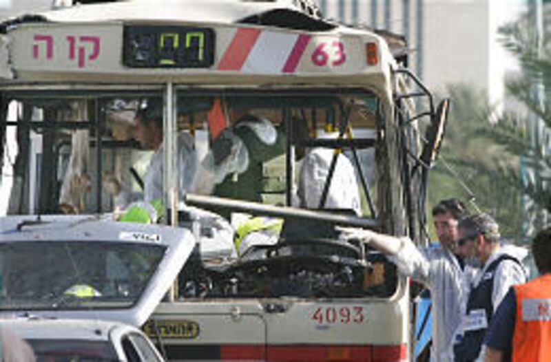 Israeli police examine the wreckage of a bus at the scene of a suicide bombing in Beersheba. The Hamas militant group said it was responsible for the two attacks Tuesday.