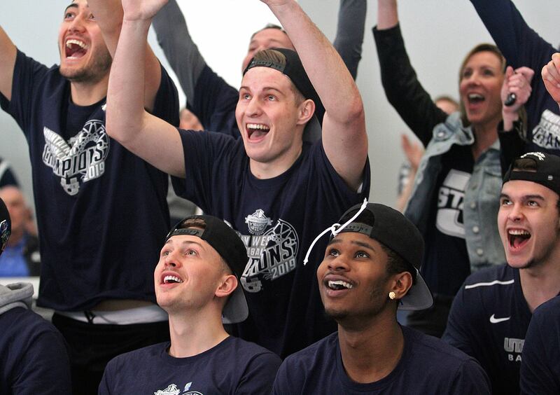 Utah State guard Sam Merrill, center, and his teammates react as the Aggies' berth in the NCAA Tournament is announced Sunday afternoon in Logan.