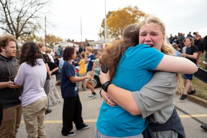 People embrace following a shooting at Central Visual Performing Arts High School in St. Louis on Oct. 24, 2022.