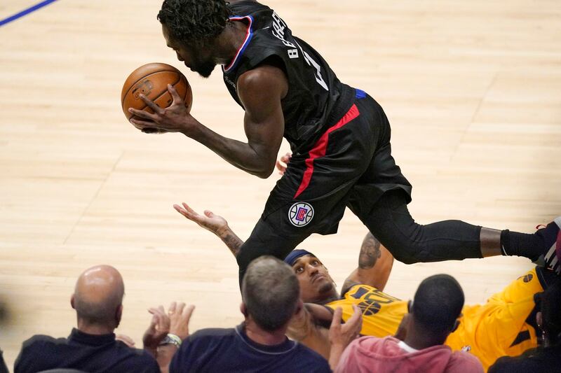 Los Angeles Clippers guard Patrick Beverley, top, dribbles as Utah Jazz guard Jordan Clarkson falls
