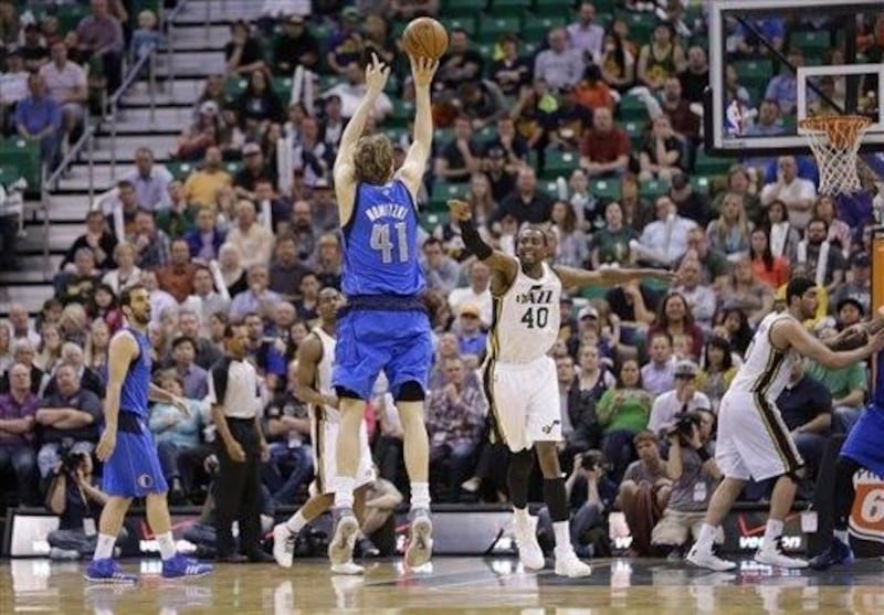 Dallas Mavericks' Dirk Nowitzki (41) shoots a 3-pointer as Utah Jazz's Jeremy Evans (40) defends in the fourth quarter of an NBA basketball game Tuesday, April 8, 2014, in Salt Lake City. The Mavericks won 95-83. (AP Photo/Rick Bowmer)