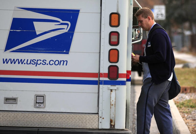 USPS mailman Bill Christensen delivers mail in Glendale area neighborhood Tuesday, Dec. 9, 2014, in Salt Lake City.