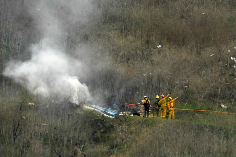 Firefighters work the scene of a helicopter crash where former NBA basketball star Kobe Bryant died in Calabasas, Calif.