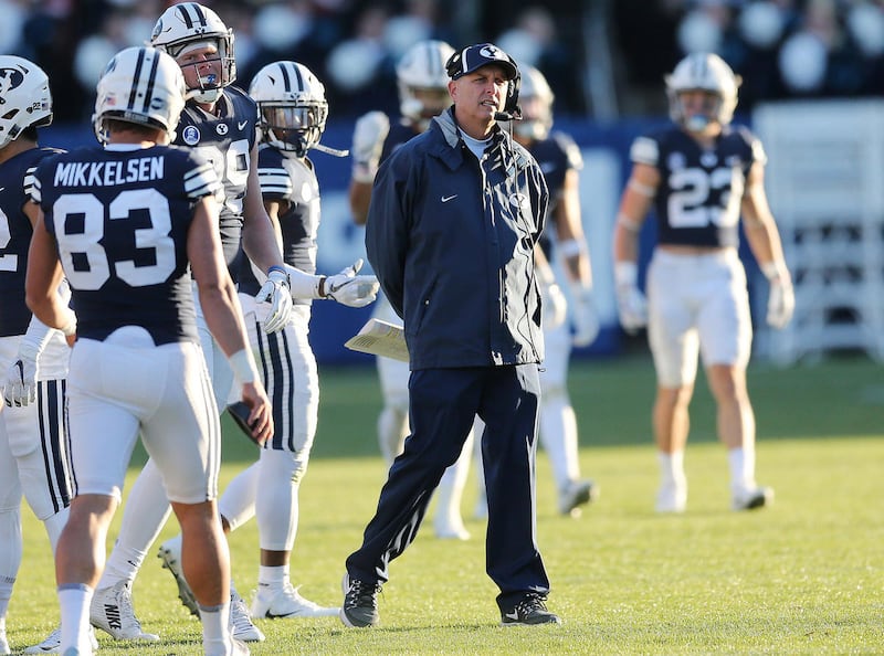BYU offensive coordinator Ty Detmer walks on to the field during a timeout in Provo on Saturday, Nov. 18, 2017.