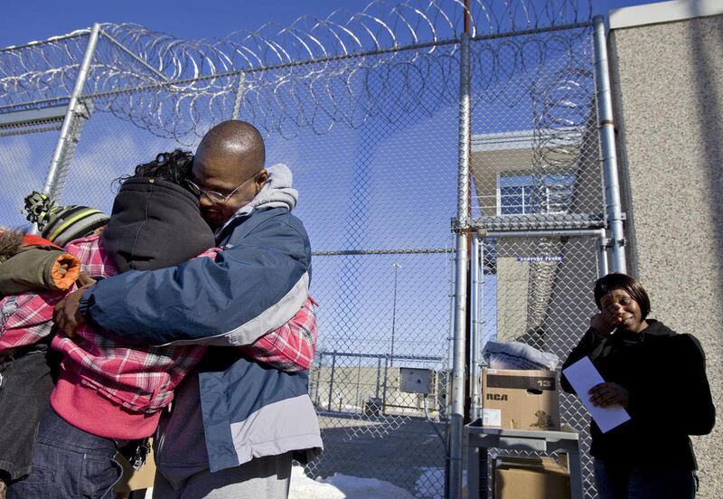 FILE - In this Jan. 30, 2009, file photo Robert Lee Stinson, second right, hugs a family friend as his sister Charlene Stinson, right, wipes her tears after Stinson walked out of the New Lisbon, Wis., Correctional Institution. Freed after 23 years behind