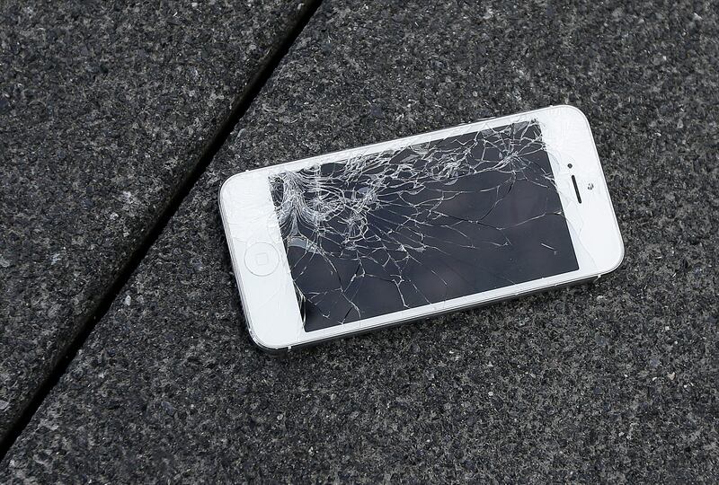Cracked iPhone on asphalt