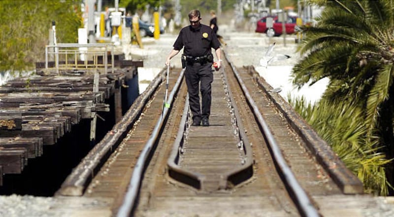 Mike Foremny, a special agent with railroad police, works the scene where three girls were killed by a train.