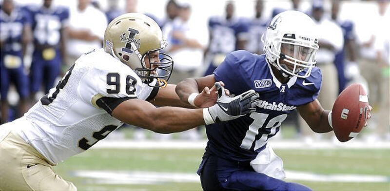 Utah State quarterback Diondre Borel, right, tries to scramble away from Idaho defensive end Josh Shaw during Saturday's WAC clash.