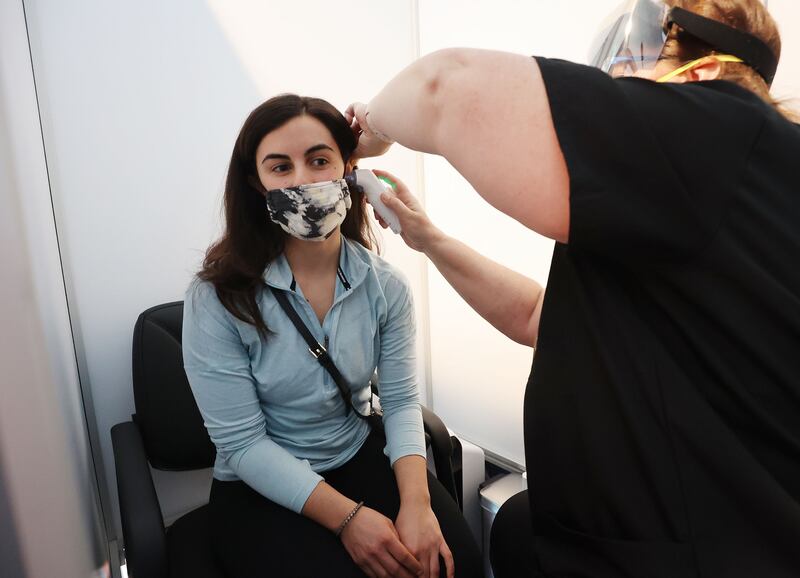 Michaela Thomas has her temperature checked at the Salt Lake City International Airport.