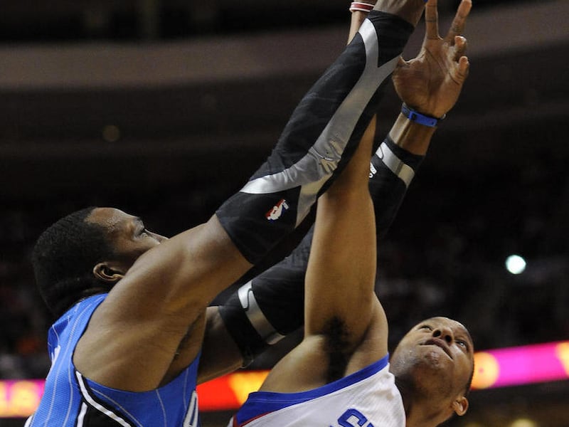 Orlando Magic's Dwight Howard, left, pulls in a rebound over Philadelphia 76ers' Evan Turner (12) in the first half of an NBA basketball game, Saturday, April 7, 2012, in Philadelphia.