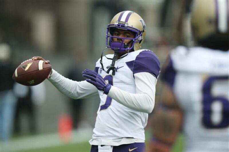 Washington quarterback Troy Williams warms up before facing Colorado in the first quarter of an NCAA college football game in Boulder, Colo., on Saturday, Nov. 1, 2014.