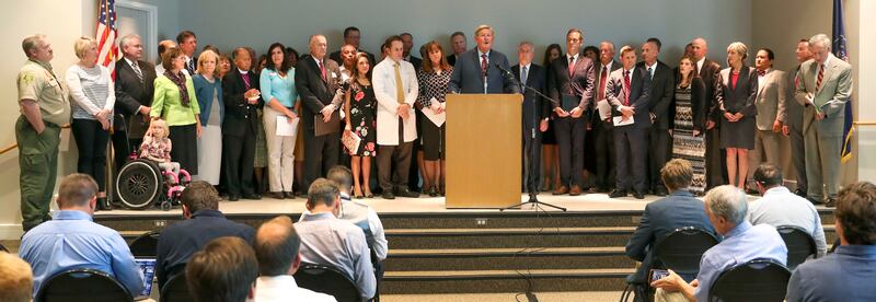 Kem Gardner, center, speaks for a broad coalition of Utah community leaders at a press conference addressing Utah's medical marijuana ballot initiative at the Utah State Office Building in Salt Lake City on Thursday, Aug. 23, 2018.