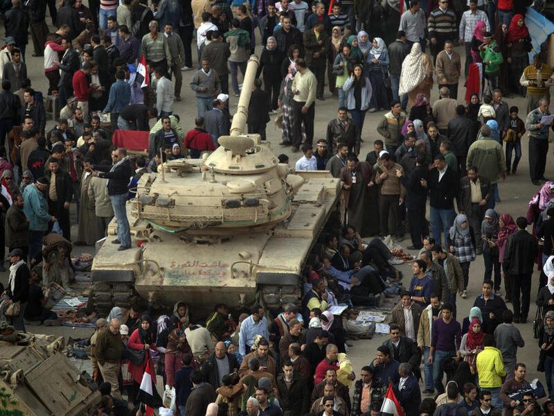 Thousands of anti-Mubarak protesters are seen next to an Egyptian army tank as they take part in a demonstration at Tahrir square in Cairo, Egypt, Tuesday, Feb. 8, 2011.