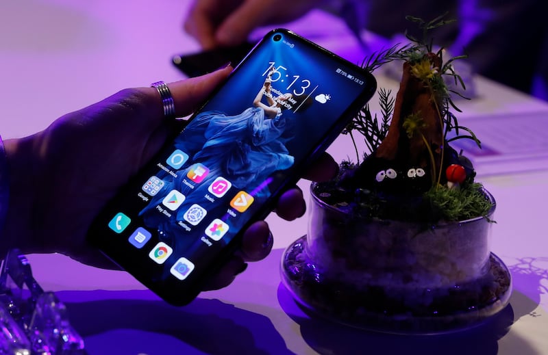 FILE - In this Tuesday, May 21, 2019 file photo, a member of the media tries out new Huawei Honor 20 series of phones following their global launch in London.