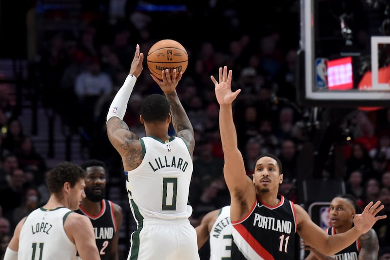 Milwaukee Bucks guard Damian Lillard (0) shoots the ball over Portland Trail Blazers guard Malcolm Brogdon (11) during the first half of an NBA basketball game in Portland, Ore., Wednesday, Jan. 31, 2024. (AP Photo/Steve Dykes)