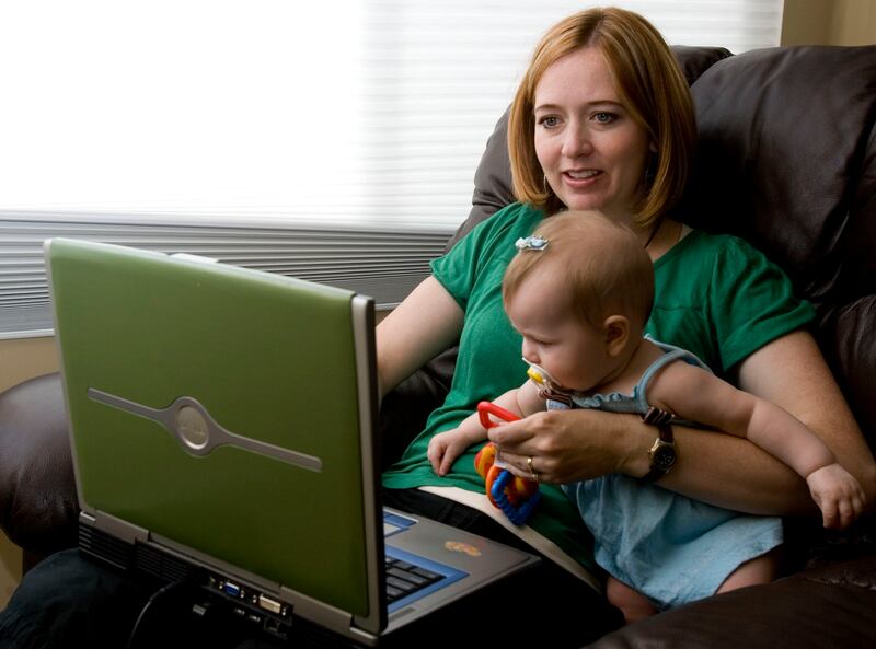 Shannon Hale, author of The Goose Girl and winner of the Newbery Award, plays with Maggie, her six-month-old, at home in South Jordan as she checks her email and blog on July 2, 2007. Shannon tries to spend as much time as she can with her two children and this place, next to the window is where she does most of her writting. Photo by Jennifer Ackerman/Deseret Morning News