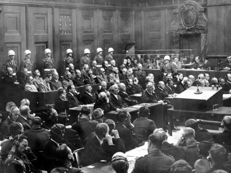 This is a general view of the War Crimes trial in Nuremberg, Germany in October of 1946, during the verdict phase of the trial. Prosecution is in the foreground and defense counsel is in front of the defendents.