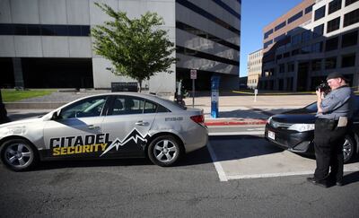 A crime scene photographer takes photos of a Citadel Security vehicle at the scene of a fatal shooting, involving a Citadel Security guard, between the Heber M. Wells Building and the Olene S. Walker Building in Salt Lake City on Wednesday, June 20, 2018.