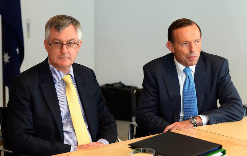 Australian Prime Minister-elect Tony Abbott, right, meets with Treasury Secretary Martin Parkinson in Sydney Sunday, Sept. 8, 2013. A new government prepared to take control of Australia on Sunday, with policies to cut pledges in foreign aid and to wind b