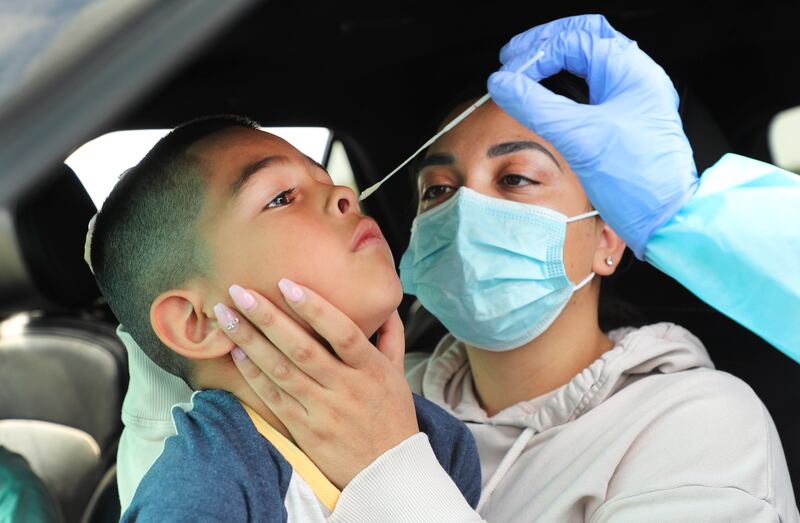 Yanet Alcaraz holds her son Nathan, 7, as he is tested for COVID-19 by the Salt Lake County Health Department in the parking lot of the Maverik Center in West Valley City on Sunday, Aug. 23, 2020. The free testing was set up for residents of Kearns, Magna, Taylorsville, West Valley City or the west side of Salt Lake City.