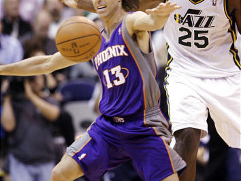 Phoenix Suns point guard Steve Nash (left) and Utah Jazz center Al Jefferson (right) fight for he ball.