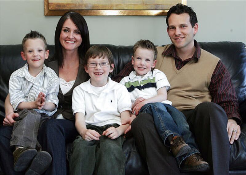 Ashlie and Brandon Belnap sit with their children Liam, left, 4, Kaleb, 6, and Aiden, 4, at their home in West Jordan on Sunday.