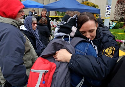 Pittsburgh Police officer Sarah Pratt gets a hug before a Shabbat morning worship service led by Rabbi Chuck Diamond outside the Tree of Life Synagogue Saturday, Nov. 3, 2018, in Pittsburgh.