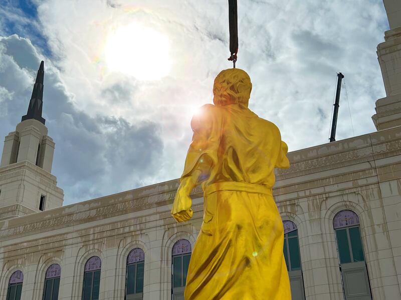 Workers prepare to hoist the Angel Moroni statue atop the Layton Utah Temple on Wednesday, March 9, 2022.
