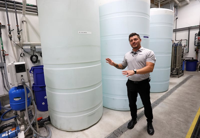 Landon Williams, general manager of Mister Car Wash Highlands West Jordan, talks about reverse osmosis water filtration, water reclamation and water optimization on Tuesday. The company says it has reduced its water use by 30%.