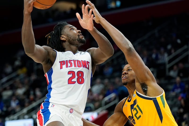 Detroit Pistons center Isaiah Stewart, wearing white, is defended by Utah Jazz center Hassan Whiteside