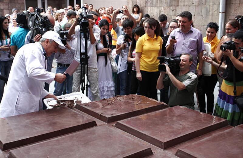 A candy factory worker chops small pieces of chocolate for people to taste, off a 9,702-pound chocolate bar produced by the Grand Candy factory in the Yerevan, Armenia, on Saturday. The candy bar was recently certified as the world's biggest.