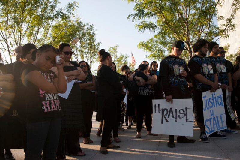 FILE - People listen to a prayer during a vigil for Siale Maveni Angilau, who was shot and killed in federal court by a U.S. marshal on April 2, on the steps of the Federal Courthouse, Wednesday, June 11, 2014.