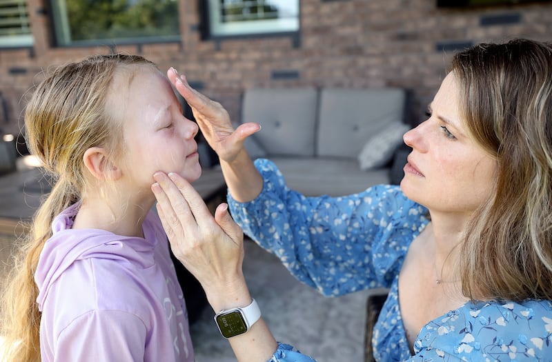 MaryAnn Gerber puts sunscreen on her daughter Maggie Gerber, 8, at their home in Layton.