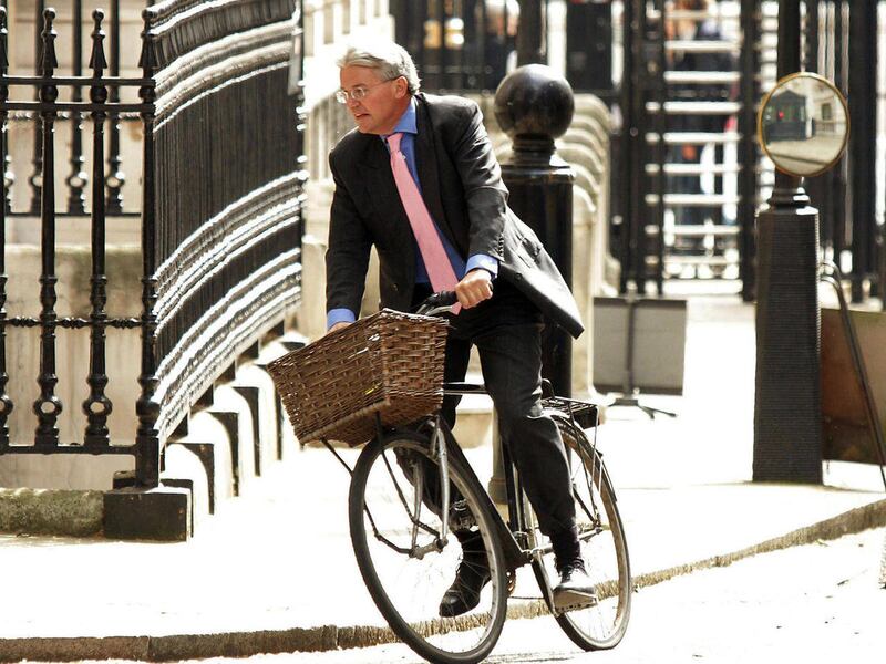 FILE - A May 17, 2011 photo from files showing Government chief whip Andrew Mitchell arriving on his bicycle at Downing Street, London. The British Cabinet minister has apologized for an outburst in which he reportedly called police officers "plebs" — a d