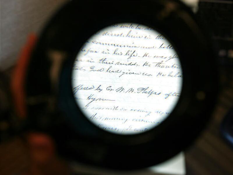 A magnifying glass is used to read a third-level verification of a report of a sermon by Joseph Smith from<BR> April 1844. About 5,000 of his documents are stored at the Church Office Building in Salt Lake City. <BR>