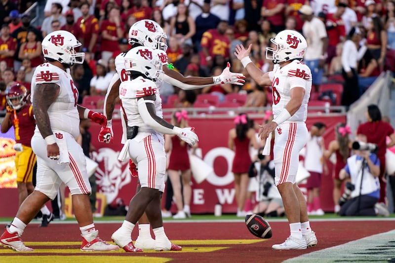 Utah quarterback Bryson Barnes, right, celebrates with teammates offensive lineman Kolinu'u Faaiu, left, running back Jaylon Glover, second from left, and tight end Landen King during game against Southern California Saturday, Oct. 21, 2023, in Los Angeles.