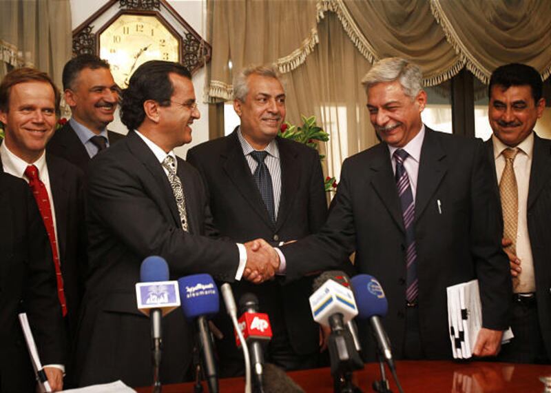 Mounir Bouaziz, Vice President of Shell Upstream International, left, shakes hand with Abdul-Mehdi Al-Amidi, second right, the Deputy Director-General of the Department contracts and permits, as Abdulkareem Luaibi, the Iraqi deputy Oil Minister, center, l