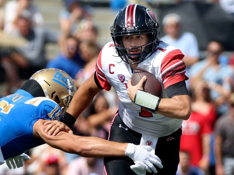 Utah quarterback Cameron Rising runs past UCLA linebacker Laiatu Latu at the Rose Bowl in Pasadena, Calif.