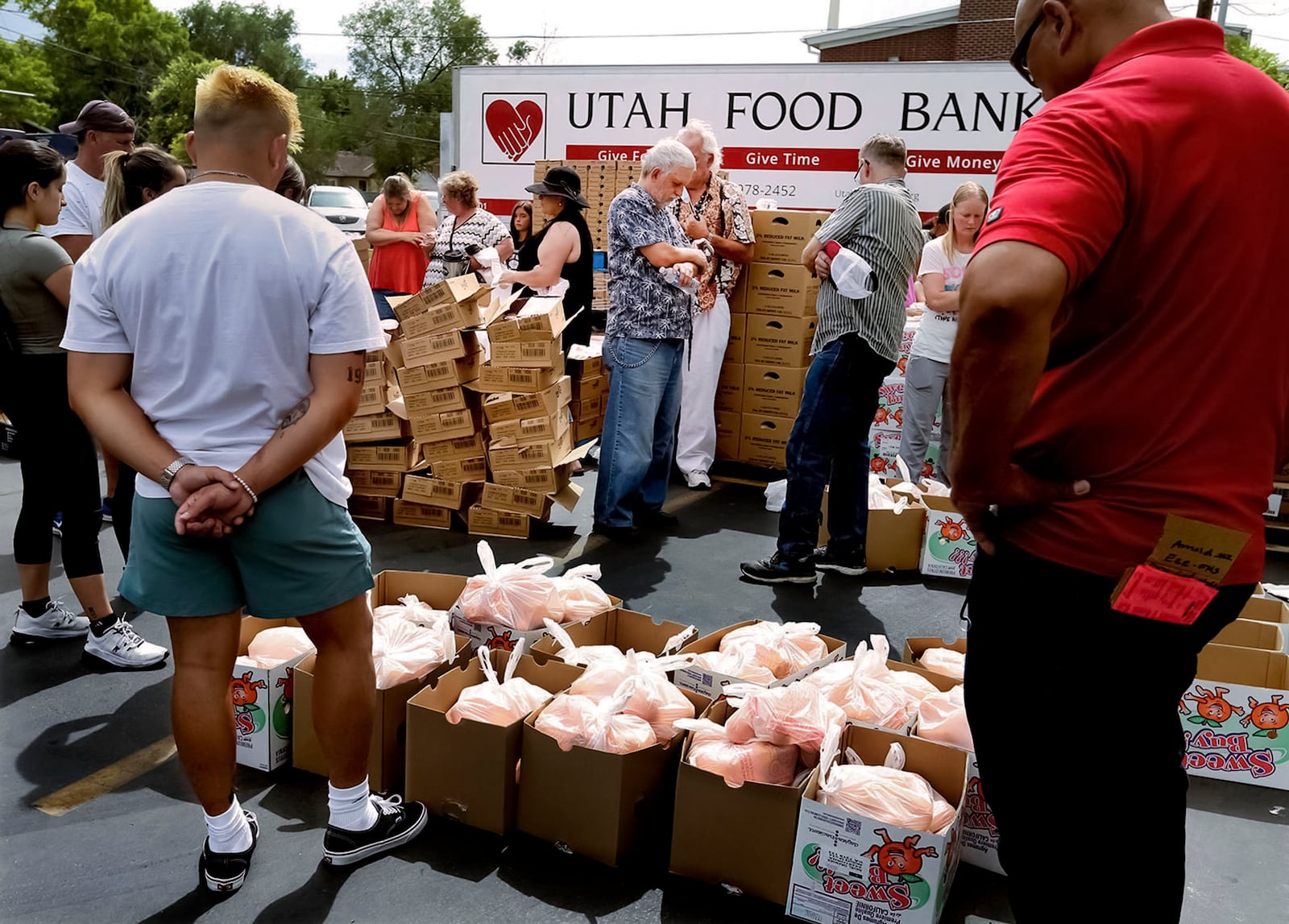 Volunteers pray before handing out food at a Utah Food Bank mobile pantry.