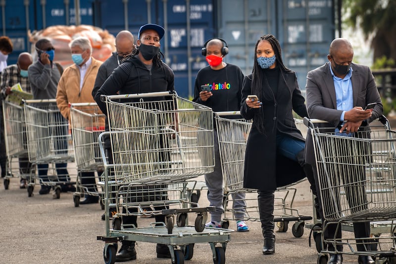 Customers lineup to enter an hyper store in Johannesburg, South Africa, Tuesday, Aug. 18, 2020.