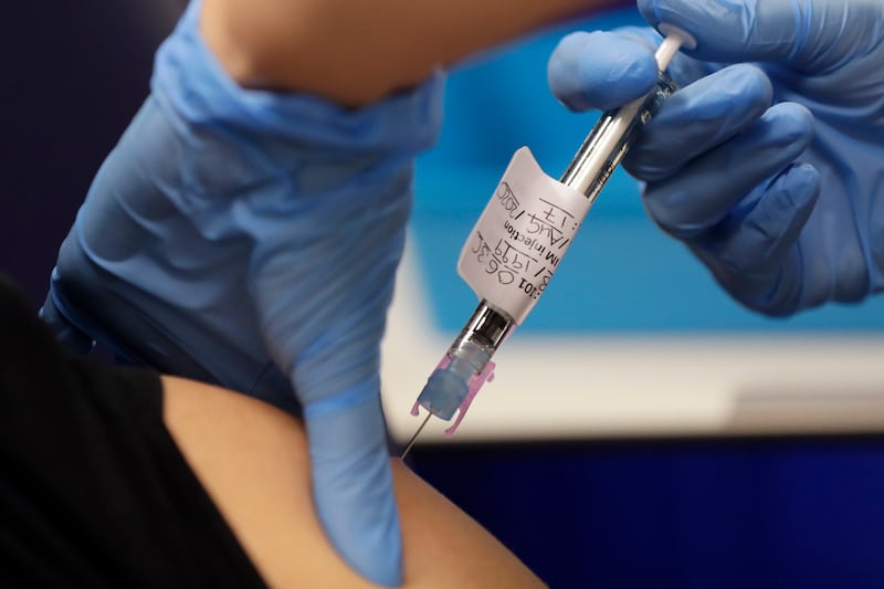 In this file photo dated Wednesday, Aug. 5, 2020, a volunteer is injected with a trial vaccine as part of an Imperial College vaccine trial, at a clinic in London.